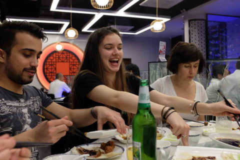 Excited students sitting at a dinner table 