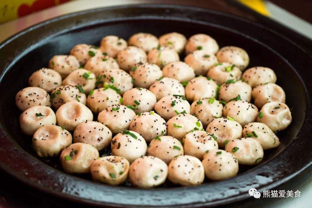 生煎包 (shengjianbao) is a popular Shanghainese food. It is cooked in a big pan as shown in the photo.